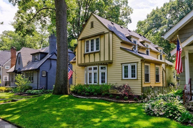 view of front facade with a chimney and a front lawn