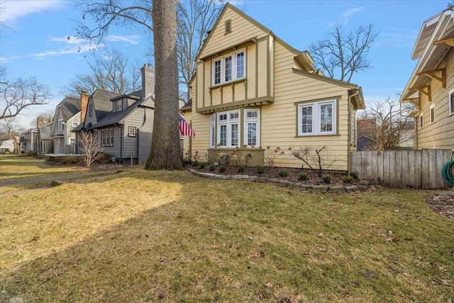 exterior space featuring a residential view, a front lawn, and fence