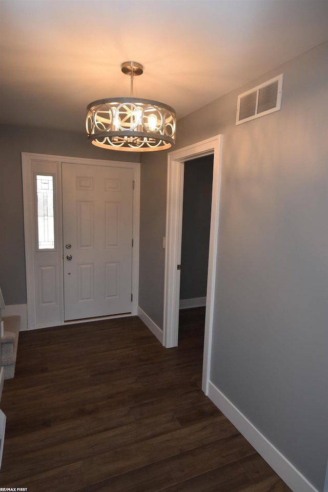 entrance foyer featuring a notable chandelier, baseboards, visible vents, and dark wood-style flooring