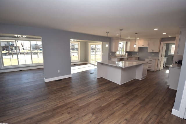 kitchen featuring recessed lighting, dark wood-style flooring, a sink, white cabinetry, and open floor plan