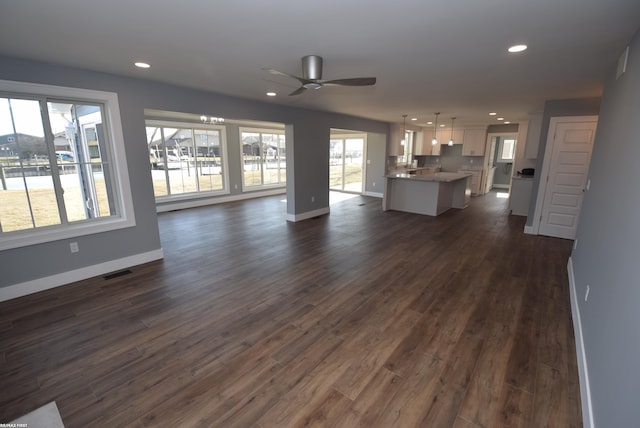 unfurnished living room featuring recessed lighting, baseboards, and a healthy amount of sunlight