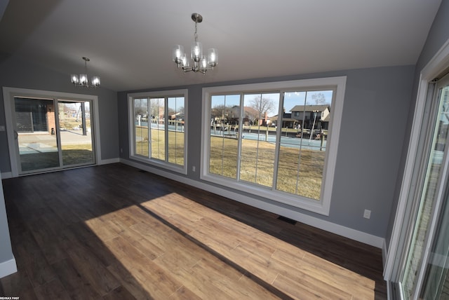 unfurnished dining area featuring visible vents, baseboards, an inviting chandelier, and dark wood-style flooring