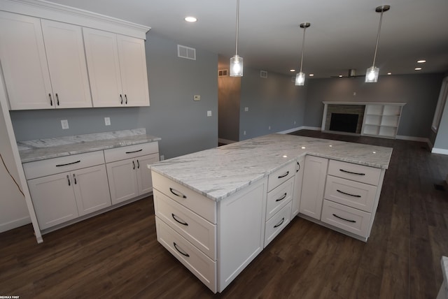 kitchen featuring visible vents, dark wood-style floors, open floor plan, and white cabinetry