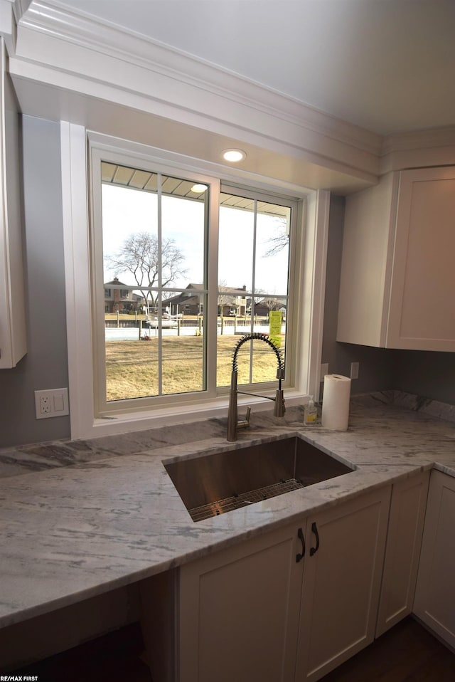 kitchen featuring a sink and light stone counters