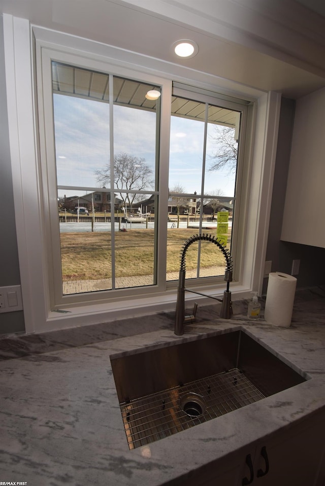 details featuring light stone countertops and a sink