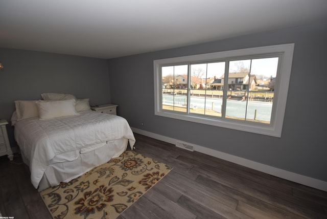 bedroom featuring dark wood-type flooring, baseboards, and visible vents