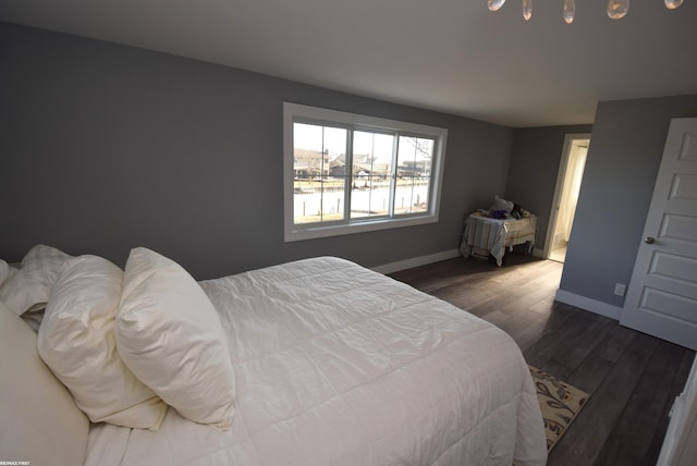 bedroom featuring baseboards and dark wood finished floors