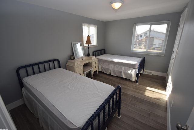 bedroom featuring baseboards and dark wood-style flooring