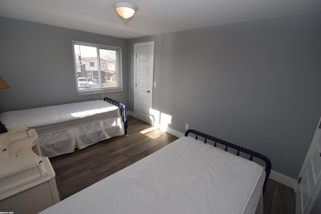 bedroom with dark wood finished floors and baseboards