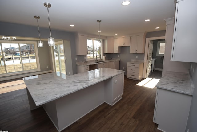 kitchen with dark wood finished floors, white cabinets, recessed lighting, and a sink