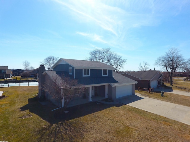 traditional-style house with an attached garage, concrete driveway, and a front yard