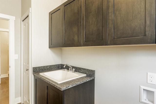 laundry room with baseboards and a sink