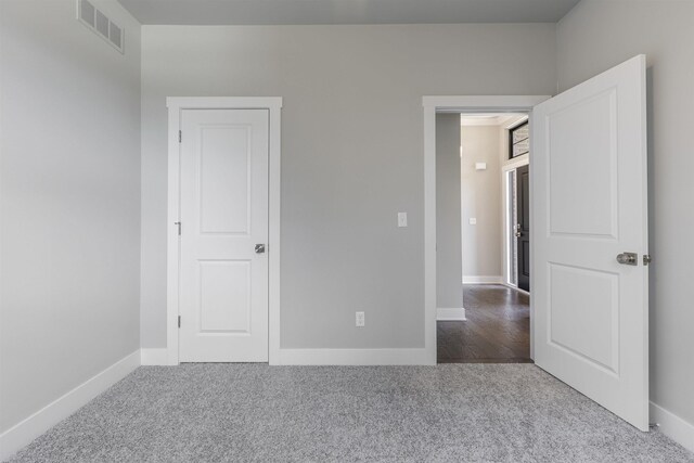 unfurnished bedroom featuring visible vents, baseboards, and carpet