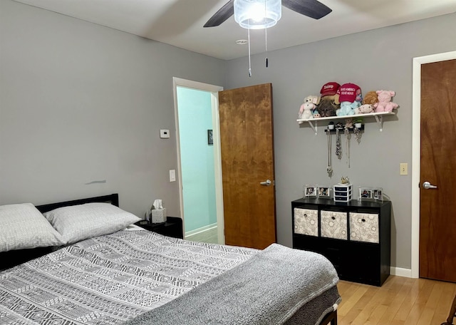 bedroom featuring a ceiling fan, light wood-type flooring, and baseboards