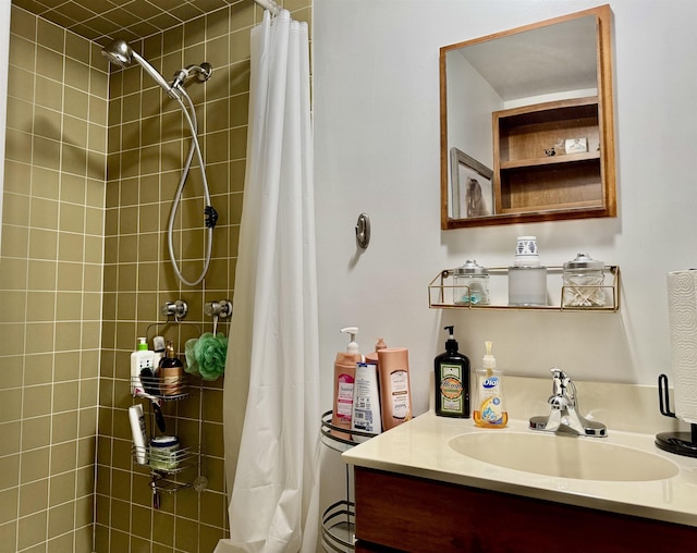 bathroom featuring tiled shower and vanity