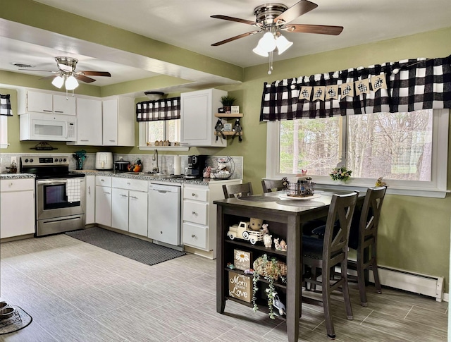 kitchen featuring white cabinetry, white appliances, plenty of natural light, and a baseboard heating unit