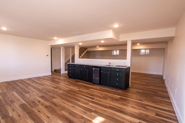 kitchen featuring dark wood finished floors, wine cooler, dark cabinets, and a sink