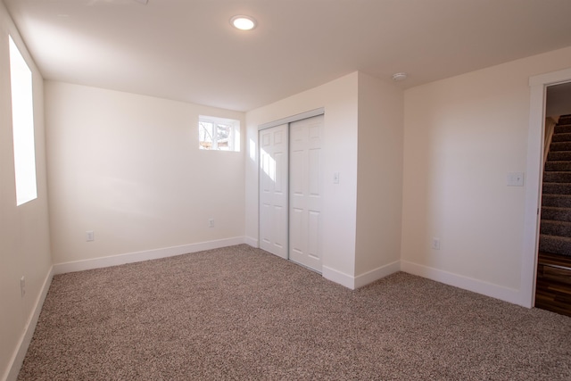 unfurnished bedroom with a closet, baseboards, and carpet