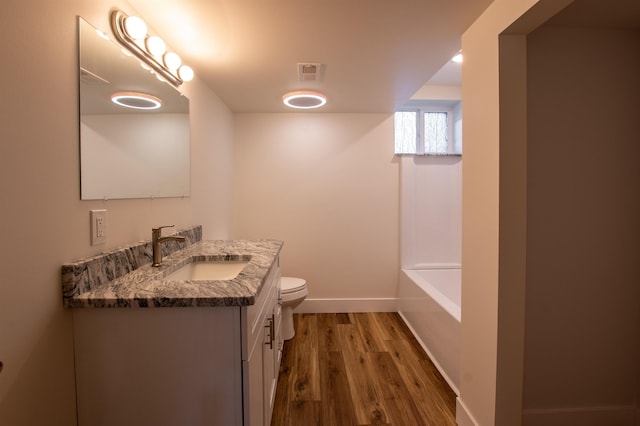 full bathroom with visible vents, baseboards, toilet, wood finished floors, and vanity