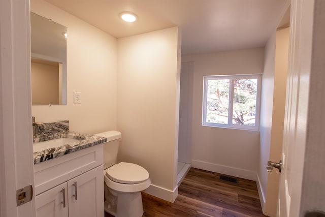 bathroom with visible vents, toilet, wood finished floors, baseboards, and vanity