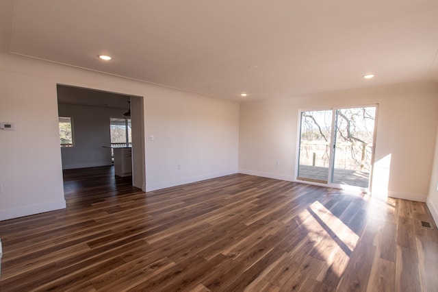 spare room featuring a wealth of natural light, dark wood-type flooring, and recessed lighting