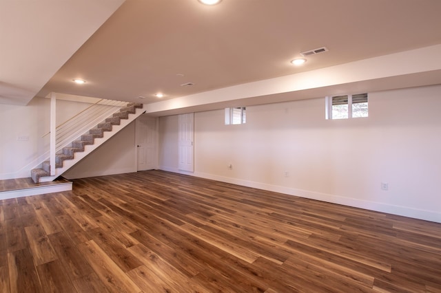 below grade area featuring visible vents, dark wood-style floors, recessed lighting, baseboards, and stairs