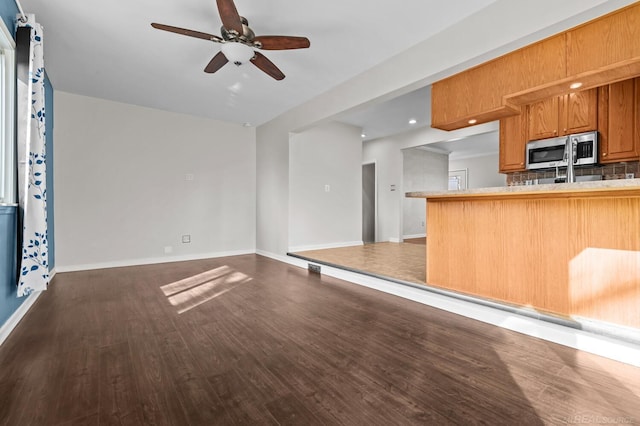 unfurnished living room featuring recessed lighting, baseboards, dark wood-style floors, and a ceiling fan