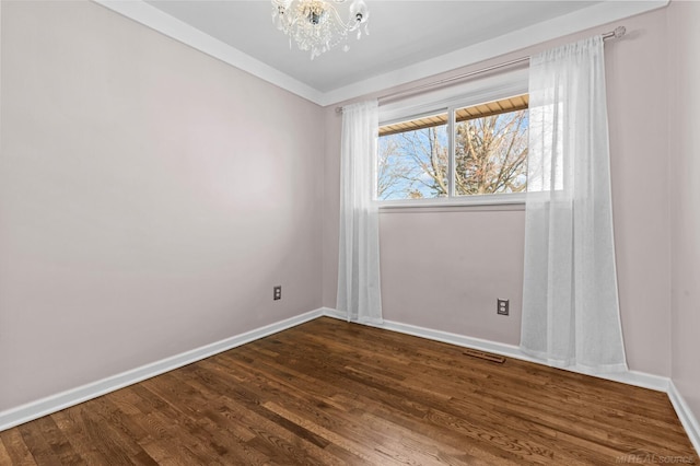 unfurnished room with dark wood-style floors, baseboards, and an inviting chandelier