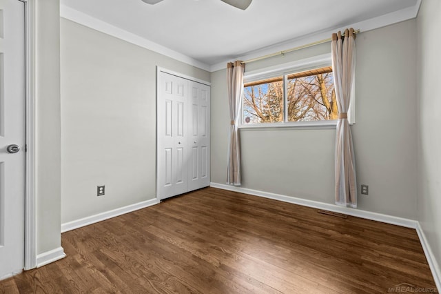 unfurnished bedroom with wood finished floors, visible vents, baseboards, ceiling fan, and a closet