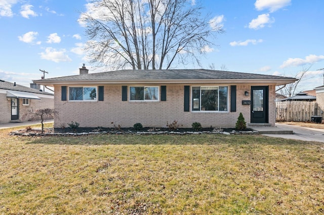 ranch-style home with a front lawn, fence, brick siding, and a chimney