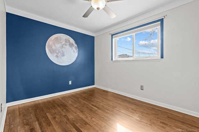 unfurnished room featuring baseboards, wood finished floors, and a ceiling fan