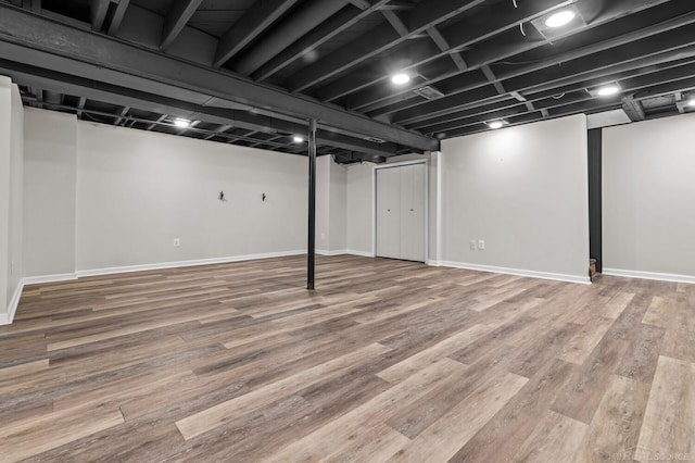 finished basement featuring wood finished floors and baseboards