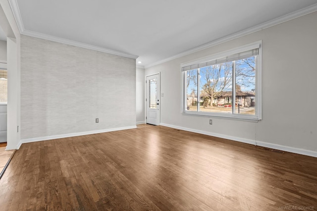 unfurnished living room featuring baseboards, wood finished floors, and ornamental molding