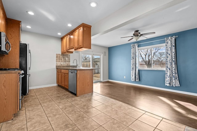 kitchen with plenty of natural light, open floor plan, appliances with stainless steel finishes, and brown cabinets