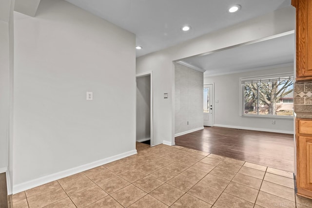 spare room with crown molding, light tile patterned floors, recessed lighting, and baseboards