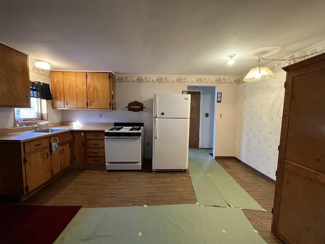 kitchen featuring wallpapered walls, baseboards, dark wood-style floors, white appliances, and a sink