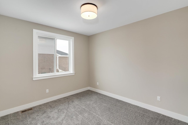 carpeted empty room featuring baseboards and visible vents