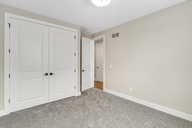 unfurnished bedroom featuring visible vents, baseboards, a closet, and carpet flooring