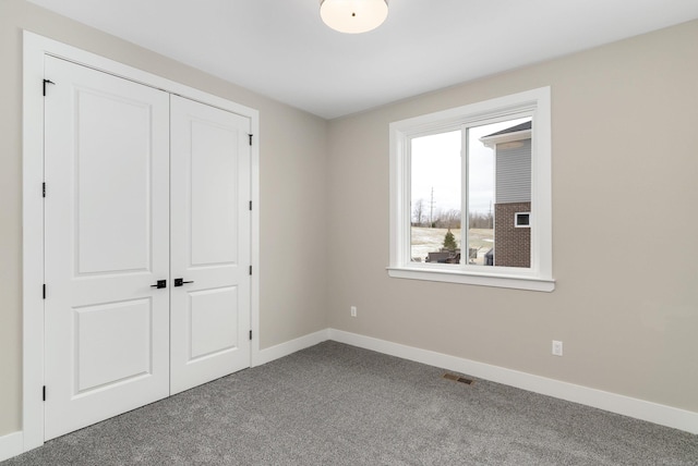 unfurnished bedroom featuring a closet, baseboards, visible vents, and carpet flooring