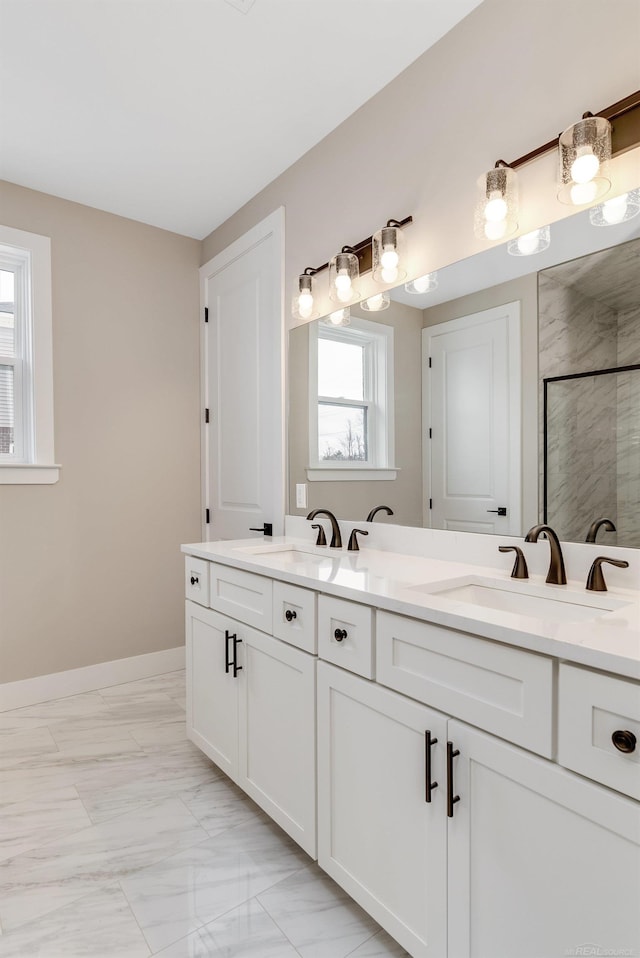 bathroom featuring a wealth of natural light, a shower stall, and a sink