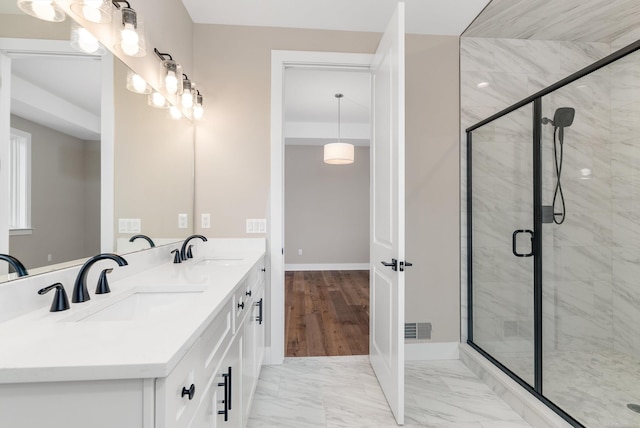 bathroom featuring a sink, visible vents, marble finish floor, and a stall shower