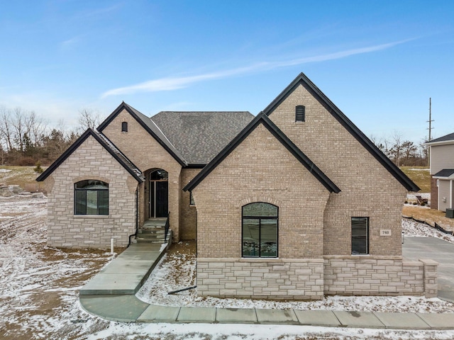 french country style house with stone siding and brick siding