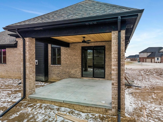 exterior space with brick siding, a shingled roof, a patio, and a ceiling fan