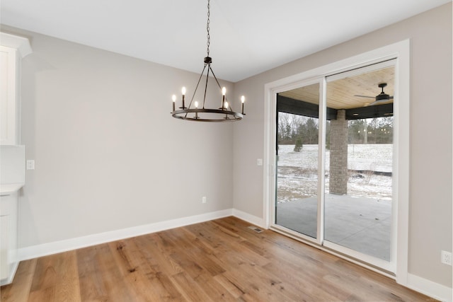 unfurnished dining area featuring a notable chandelier, light wood-style flooring, visible vents, and baseboards