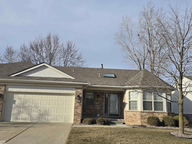 single story home with concrete driveway, an attached garage, brick siding, and a shingled roof