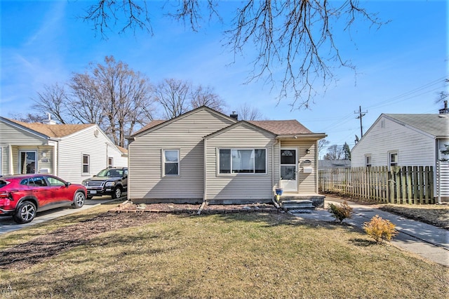 bungalow-style house featuring a front lawn and fence