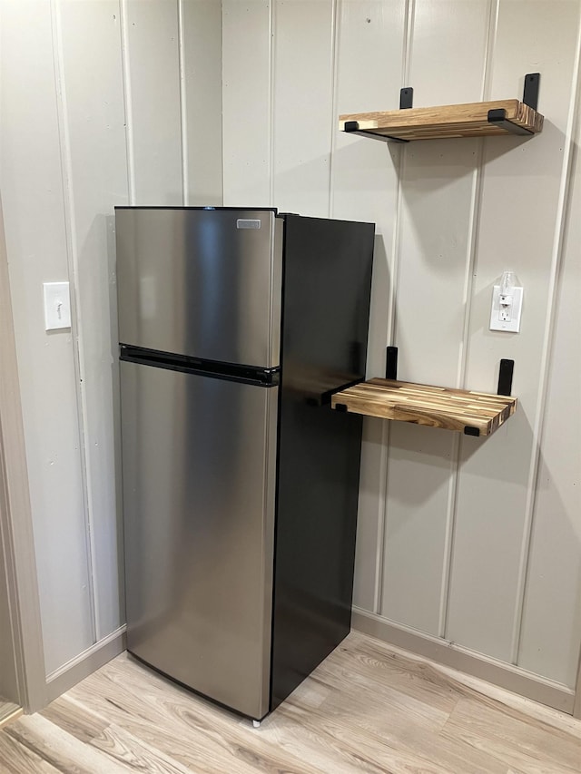 kitchen with white cabinets, light wood finished floors, freestanding refrigerator, and butcher block counters