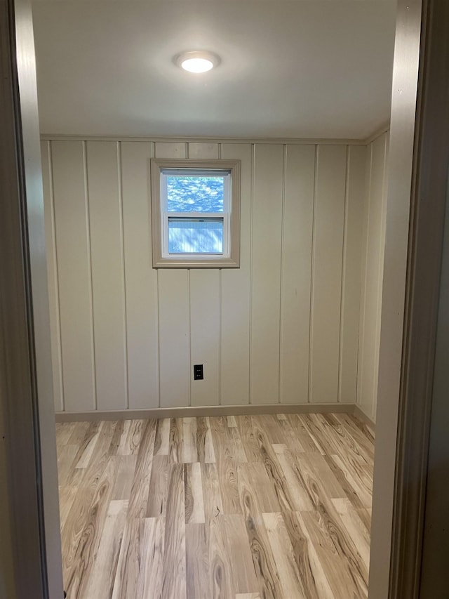 unfurnished room with a decorative wall and light wood-type flooring