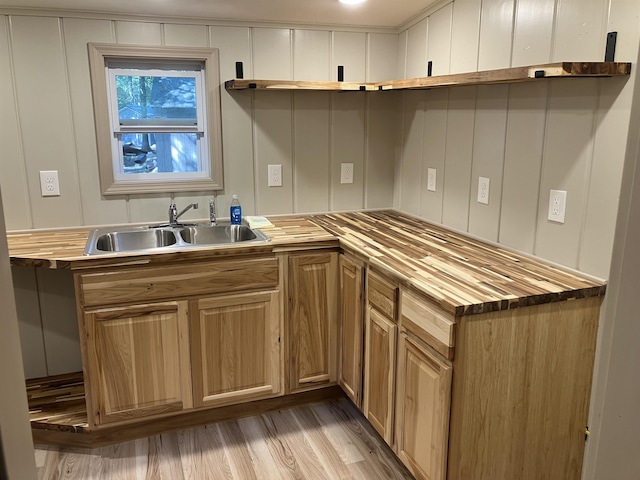 kitchen featuring wood counters, light wood-type flooring, and a sink