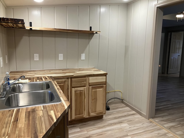 kitchen featuring a sink, butcher block countertops, and light wood finished floors